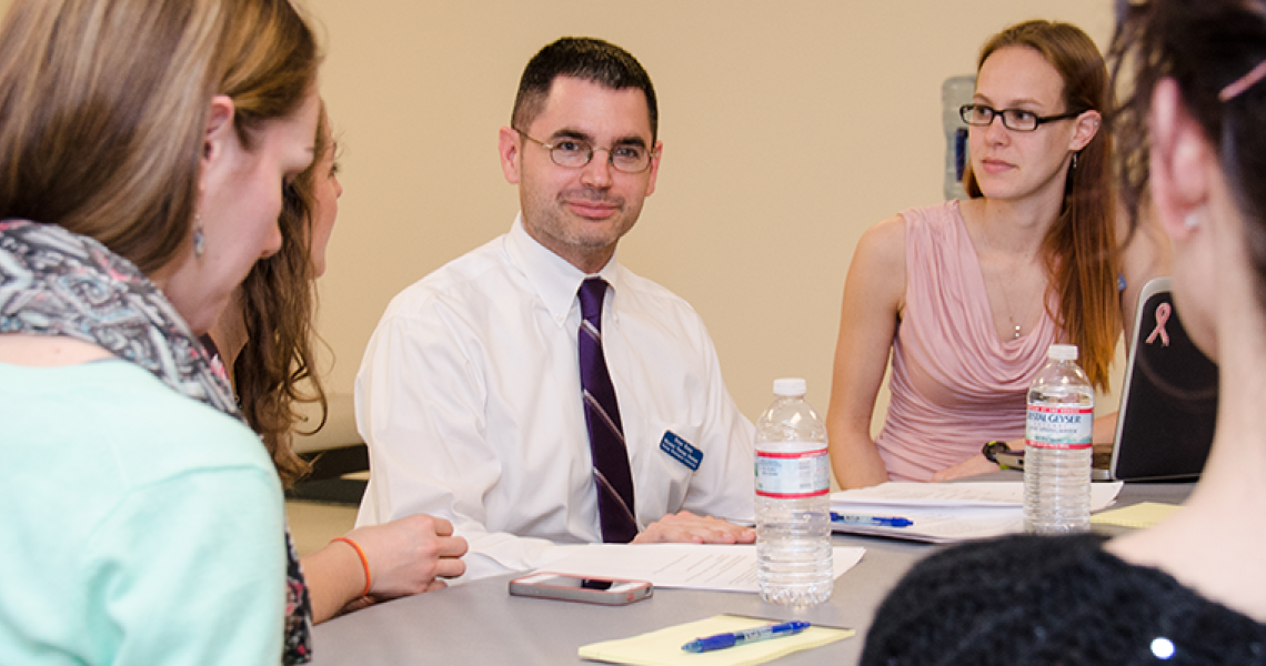 Students sitting around a table at a meeting