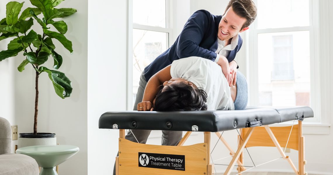 Alumni Josh D'Angelo treating patient on treatment table in sunlit room