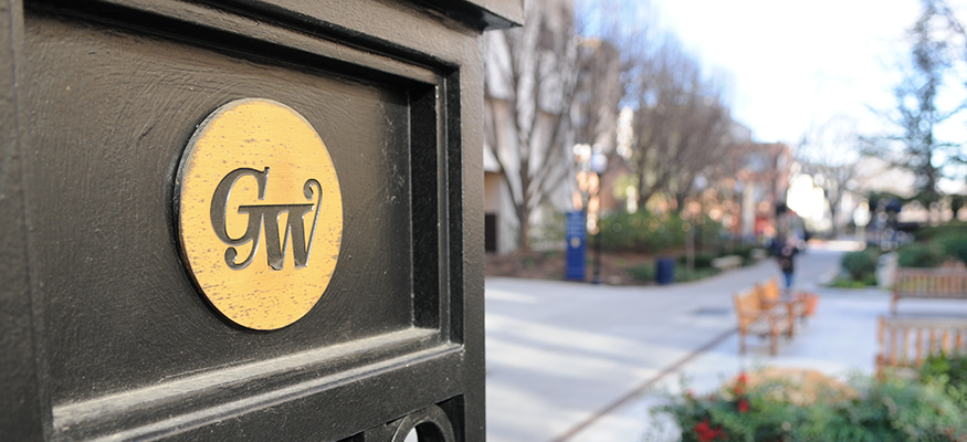 GW symbol on a campus gate overlooking campus