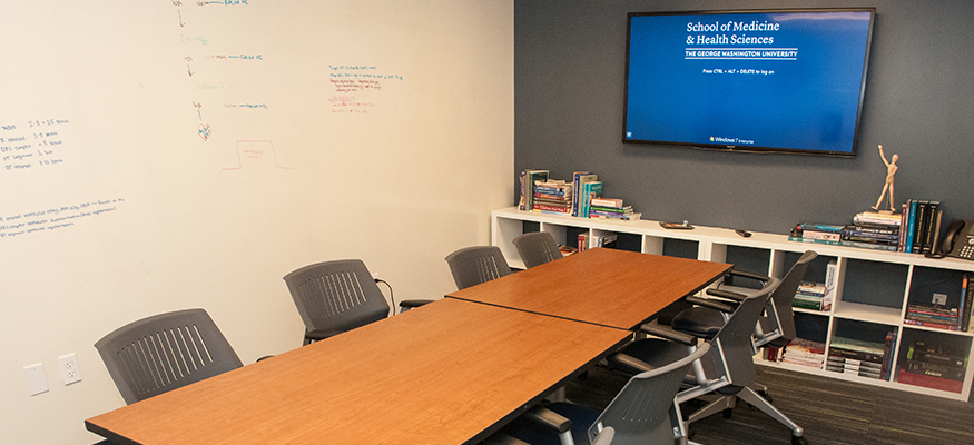 conference room with table and chairs and a tv screen