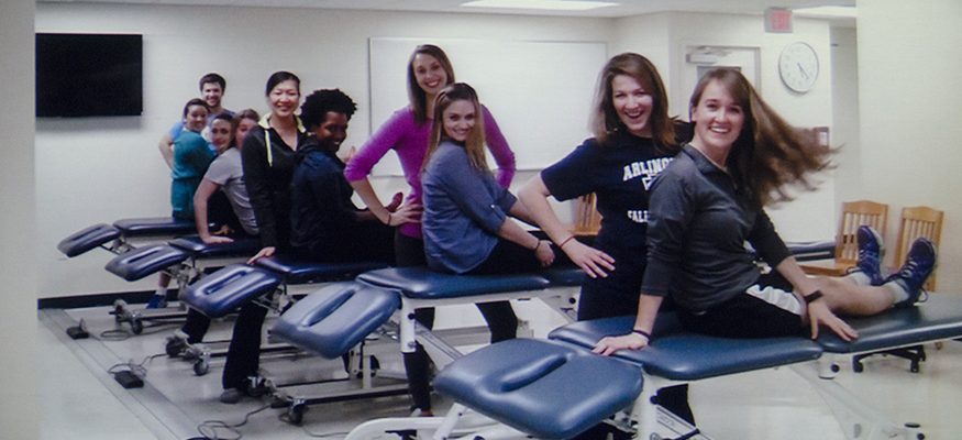 Follies - PT students looking at the camera sitting on PT tables
