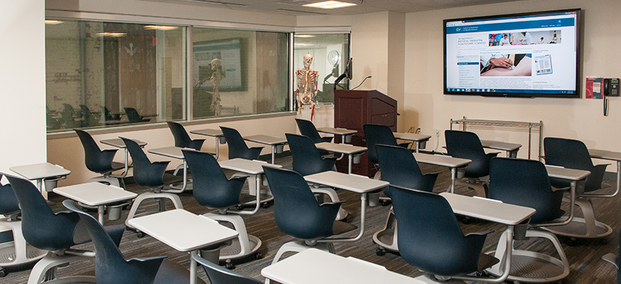 lecture room with chairs and tables and a tv monitor