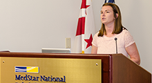PT Resident speaking at a lectern with MedStar National on the front