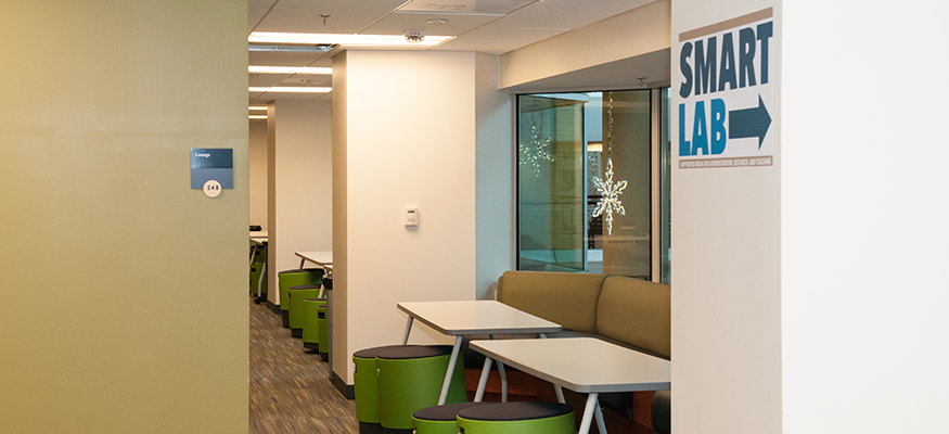 hallway with tables, chairs, and "Smart Lab" written on the wall