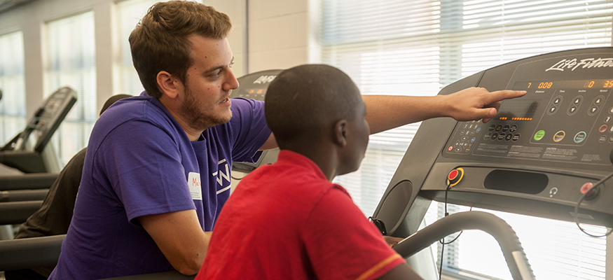 PT student showing a student how to use a treadmill