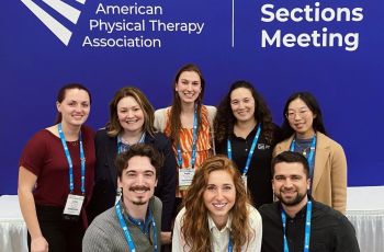 GW students and adjunct faculty pose in front of APTA CSM sign